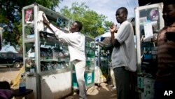 FILE - A mobile phone vendor from Cameroon prepares for a day of business in Juba, southern Sudan.