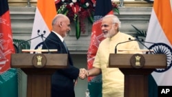 Indian Prime Minister Narendra Modi, right, shakes hands with Afghan President Ashraf Ghani after signing of bilateral agreements in New Delhi, India, Wednesday, Sept. 14, 2016.