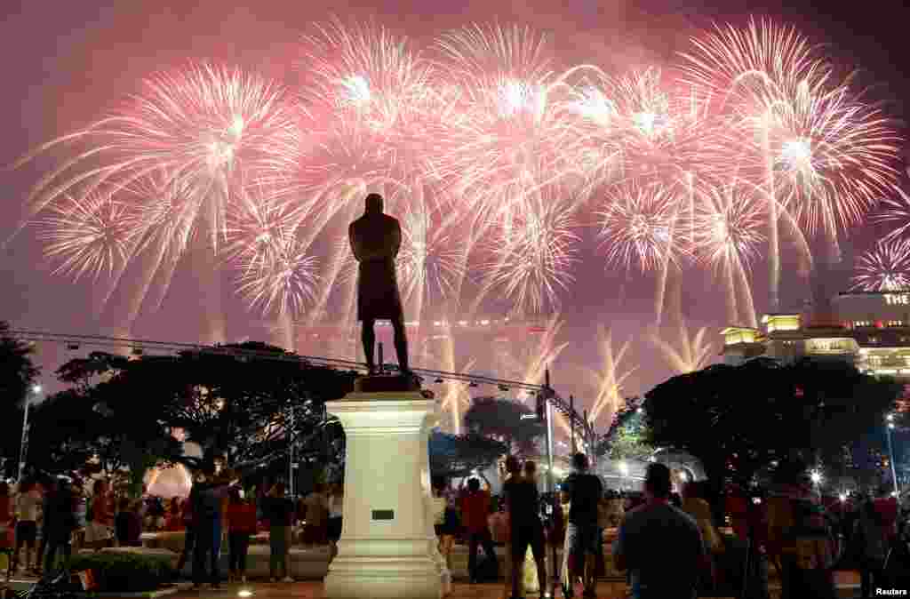 A statue of Sir Stamford Raffles is seen as spectators watch fireworks explode during Singapore&#39;s 54th National Day Parade in Singapore.