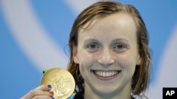 United States' Katie Ledecky shows off her gold medal after setting a new world record in the women's 400-meter freestyle final during the swimming competitions at the 2016 Summer Olympics, Aug. 8, 2016, in Rio de Janeiro, Brazil. 