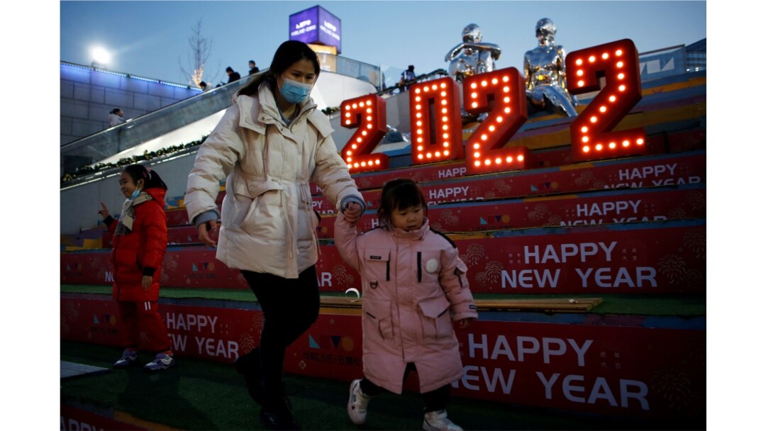 Seorang perempuan mengenakan masker pada Malam Tahun Baru di sebuah pusat perbelanjaan di Beijing, China, 31 Desember 2021. (Foto: REUTERS/Florence Lo)