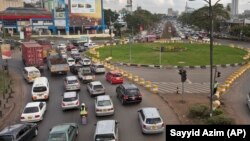 Drivers sit at a traffic circle with its exits blocked off by barriers to prevent right turns, on a highway in downtown Nairobi, Kenya Tuesday, April 14, 2015. (AP Photo/Sayyid Azim)