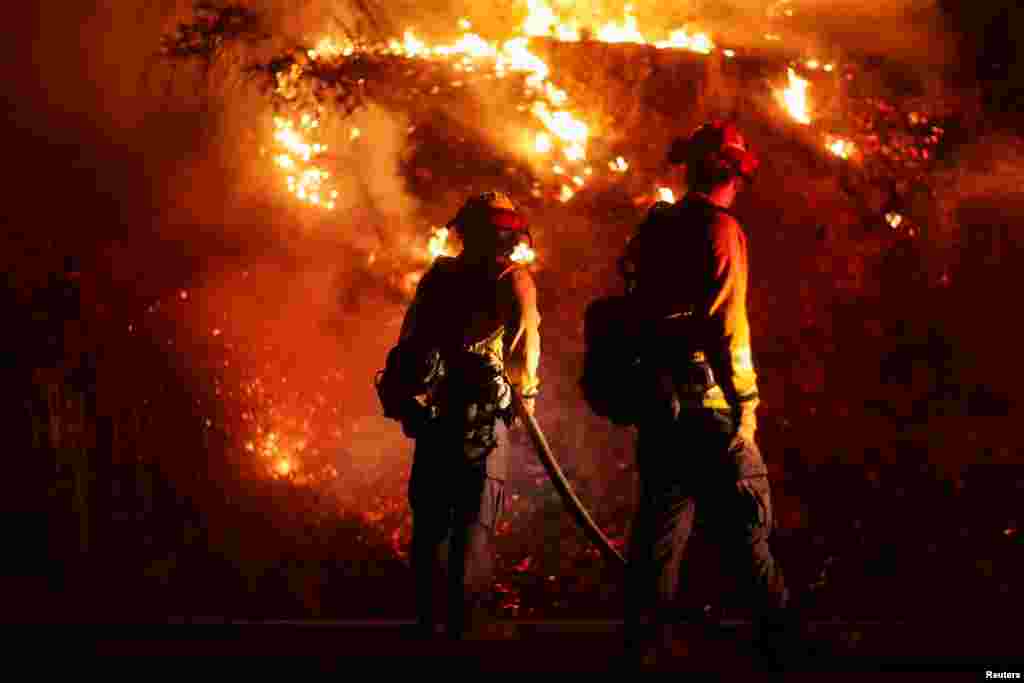 Firefighters extinguish spot fires along Route 89 Dixie Fire in Moccasin, now over 200,000 acres, California, July 28, 2021.