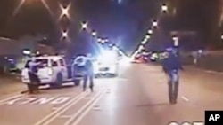 In this Oct. 20, 2014 frame from dash-cam video provided by the Chicago Police Department, Laquan McDonald walks down the street moments before being shot by police officer Jason Van Dyke. 