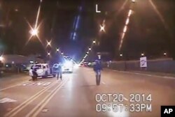 In this Oct. 20, 2014 frame from dash-cam video provided by the Chicago Police Department, Laquan McDonald walks down the street moments before being shot by police officer Jason Van Dyke.