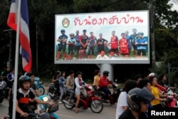 FILE - A board showing "Welcome home, boys" is seen after rescue efforts began for the 12 schoolboys and their soccer coach trapped in Tham Luang cave, in Chiang Rai, Thailand, July 9, 2018.