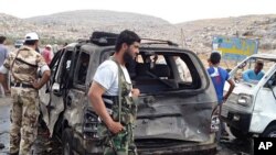 Syrian rebels look over damaged cars after a car bomb exploded at a crossing point near Syria's border with Turkey, Sept. 17, 2013.