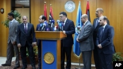 FILE - Fayez Seraj, flanked by members of the Presidential Council, speaks during a news conference at the Mitiga Naval Base in Tripoli, Libya, March 30, 2015.