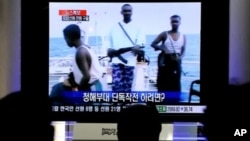 South Koreans watch a TV breaking news about South Korean navy military operation against Somali pirates in the Indian Ocean in Seoul, 21 Jan 2011
