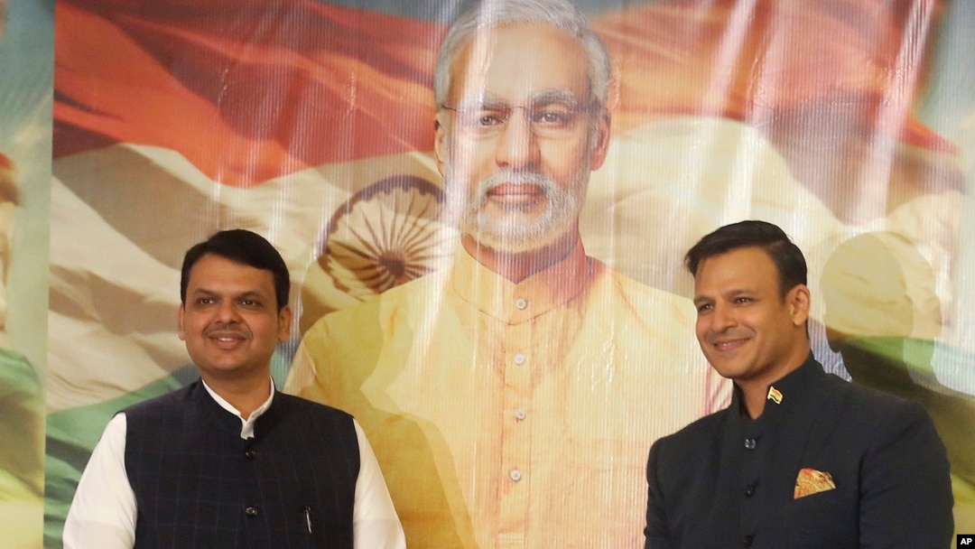 FILE - Maharashtra state Chief Minister Devendra Fadnavis, left, and Bollywood actor Vivek Oberoi stand for a photo in front of a poster for the now delayed film "PM Narendra Modi," in Mumbai, India, Jan. 7, 2019.