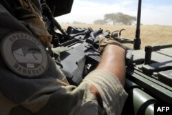 FILE - A soldier of France's Barkhane mission holds a weapon as he patrols in central Mali, in the border zone with Burkina Faso and Niger, Nov. 01, 2017.