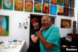 Artists Gonzalo Duran and his wife Cheri Pann laugh in the studio of their Mosaic Tile House in Venice, California, Aug. 26, 2016.