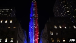 FILE - Rockefeller Center and Rockefeller Plaza is lit up in red and blue to mark the electoral progress of Hillary Clinton and Donald Trump and a map of the United States was superimposed on the skating rink, Nov. 7, 2016.