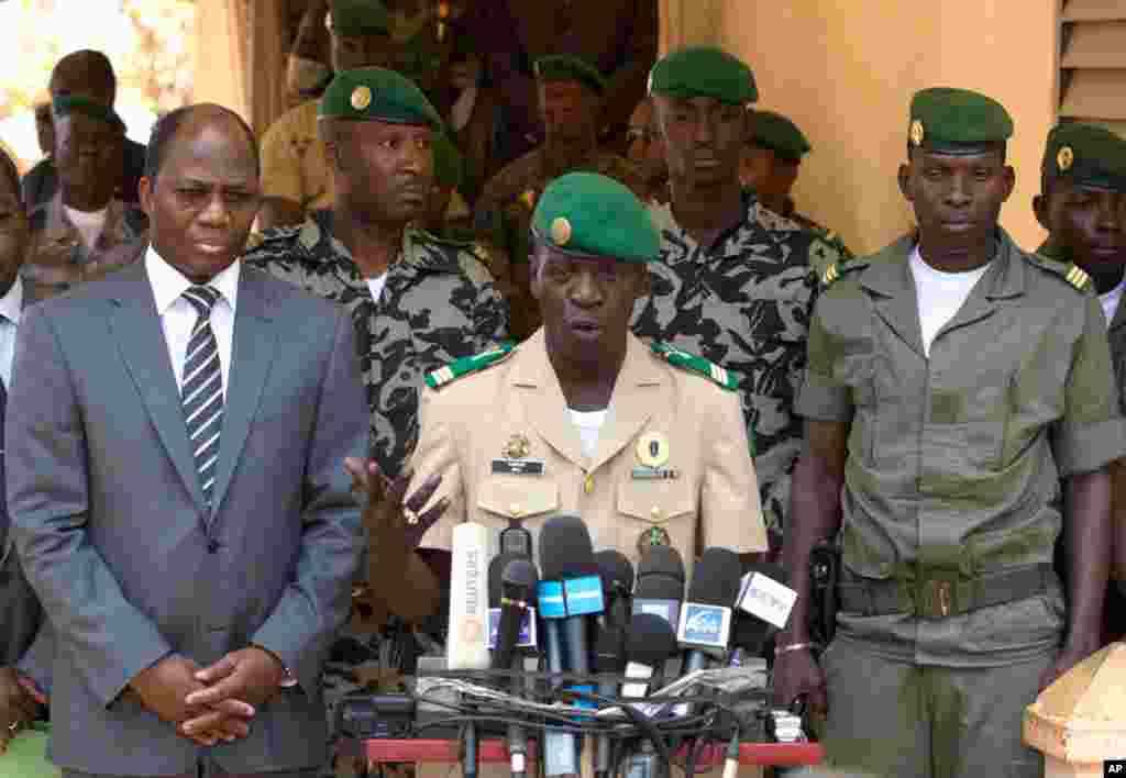 Coup leader Capt. Amadou Haya Sanogo, center, with Burkina Faso Foreign Affairs Minister Djibril Bassole (left) addresses the press at junta headquarters in Kati, outside Bamako, Mali, April 1, 2012. The leader of Mali's recent coup says he is reinstating
