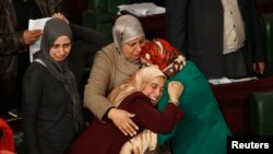 FILE - Members of the Tunisian parliament celebrate after approving the country's new constitution in the assembly building in Tunis January 26, 2014.