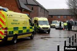 FILE - Emergency services vehicles are parked behind a pub that was visited by former Russian intelligence officer Sergei Skripal and his daughter Yulia before they were found poisoned, in Salisbury, Britain, March 28, 2018.