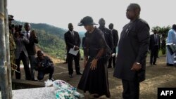 Sierra Leone's President Julius Maada Bio, right, and his wife, Fatima Bio, lay flowers on Aug. 14, 2018, at the commemoration site for the victims of last year's mudslide in Freetown.