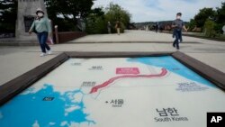 FILE - Visitors walk by a map of two Koreas showing North Korea's capital Pyongyang and South Korea's capital Seoul at the Imjingak Pavilion in Paju, South Korea, near the border with North Korea, Sept. 24, 2021. 