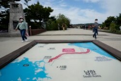 FILE - Visitors walk by a map of two Koreas showing North Korea's capital Pyongyang and South Korea's capital Seoul at the Imjingak Pavilion in Paju, South Korea, near the border with North Korea, Sept. 24, 2021.