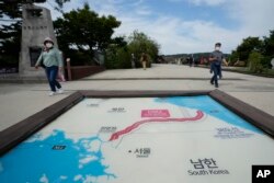 FILE - Visitors walk by a map of two Koreas showing North Korea's capital Pyongyang and South Korea's capital Seoul at the Imjingak Pavilion in Paju, South Korea, near the border with North Korea, Sept. 24, 2021.