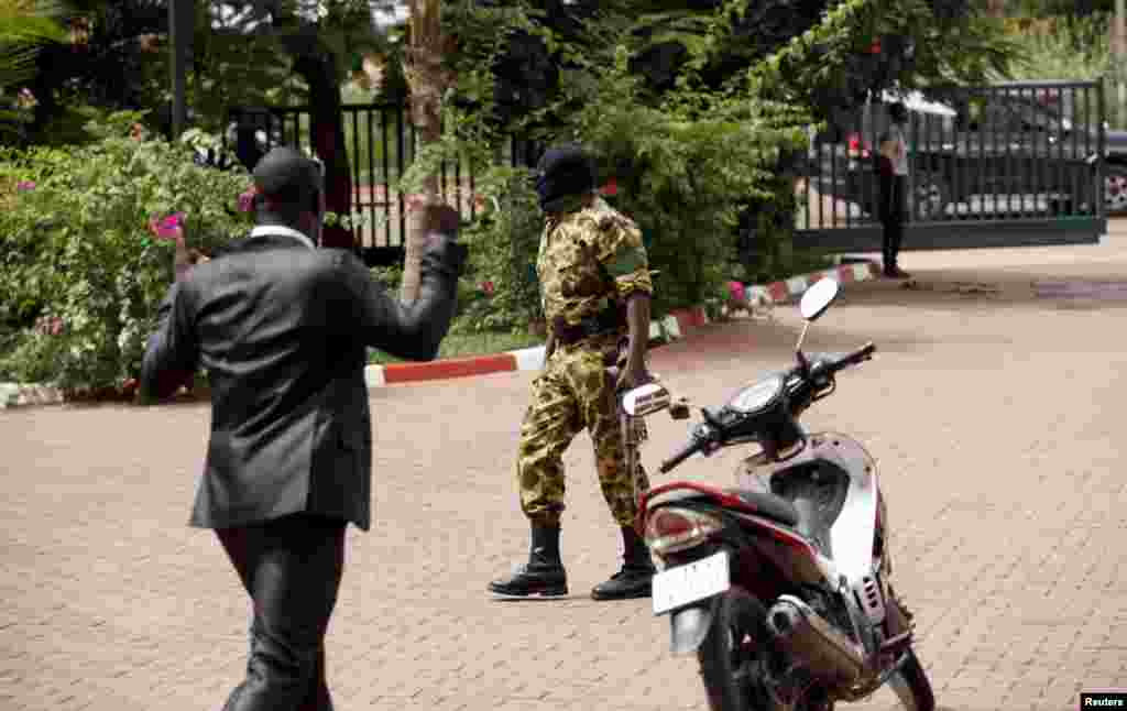 A presidential guard member wearing ski mask arrives at the Laico hotel in Ouagadougou, Burkina Faso, September 20, 2015. Pro-coup demonstrators in Burkina Faso on Sunday invaded the hotel due to host talks aimed at hammering out the details of a deal to 