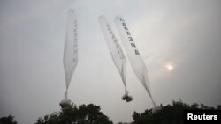 Những chiếc bong bóng bay mang theo các truyền đơn tố cáo Bình Nhưỡng được những người đào thoát khỏi Bắc Triều Tiên thả về hướng miền bắc từ một cánh đồng gần khu phi quân sự phân chia 2 miền, hôm 24/6/2012