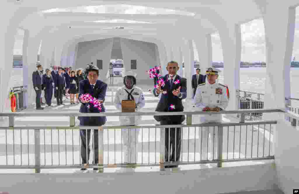 នាយករដ្ឋមន្រ្តី​ជប៉ុន​លោក​ស៊ីនហ្សូ អាបេ (ខាង​ឆ្វេង) និង​ប្រធានាធិបតី​អាមេរិក​លោក​បារ៉ាក់ អូបាម៉ា (ទីពីរ​ពីខាង​ស្តាំ) បោះ​ផ្កា​ចូល​ទៅ​ក្នុង​អណ្តូង​បួងសួង​នៅ​ឯ​កន្លែង​គោរពវិញ្ញាណក្ខន្ធ USS Arizona Memorial ជា​ផ្នែក​មួយ​នៃ​ការ​រំឮក​ពី​សង្រ្គាមលោកលើកទីពីរ​នៅ​វិមាន Pacific National Monument ក្នុង​មូលដ្ឋាន​ទ័ព​អាកាស​ចម្រុះ Pearl Harbor-Hickam កោះហាវ៉ៃ កាល​ពី​ថ្ងៃ​ទី២៧ ខែ​ធ្នូ ឆ្នាំ​២០១៦។