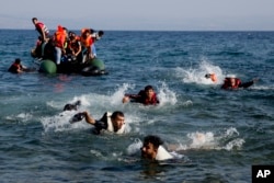 Migrant whose boat stalled at sea while crossing from Turkey to Greece swim to approach the shore of the island of Lesbos, Greece, Sept. 20, 2015.