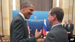 U.S. President Barack Obama, left, and Russian President Dmitry Medvedev talk and smile at each other following the conclusion of their bilateral meeting at the Nuclear Security Summit in Seoul, South Korea, March, 26, 2012. 