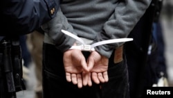 FILE - A subject stands in plastic handcuffs after being arrested by New York City Police in this November 17, 2011.