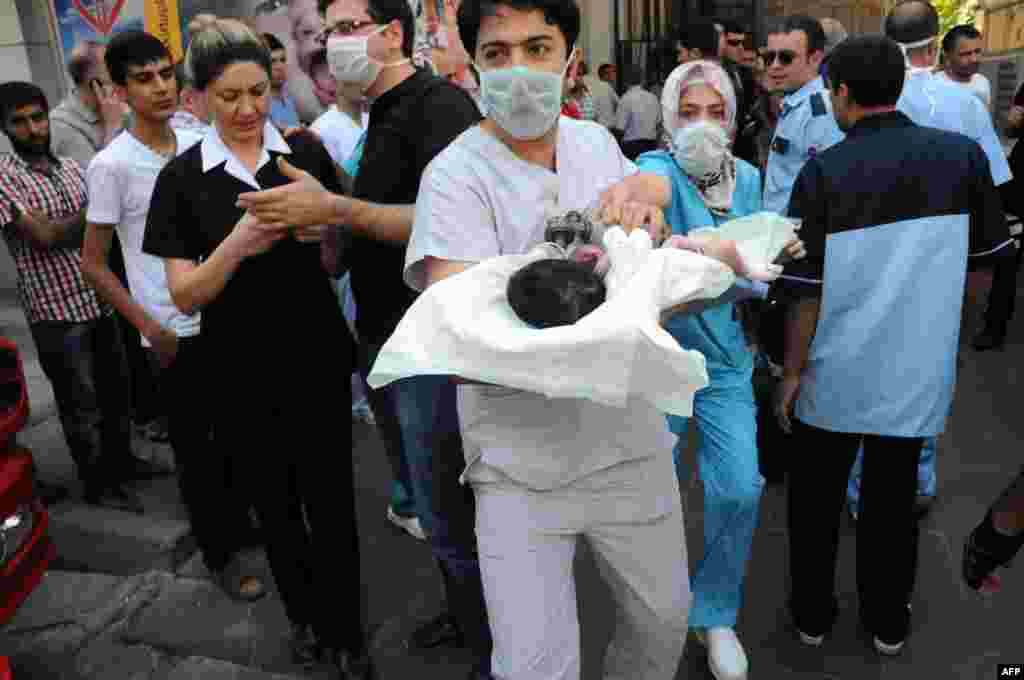 Doctors evacuate a baby from a hospital when a fire breaks out in the center of Diyarbakir, Turkey.