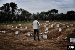 A man looks at a graveyard in Mytilene, Greece, Feb. 17, 2016, for refugees and migrants who drowned in their attempt to cross the Aegean sea from Turkey to the island of Lesbos.