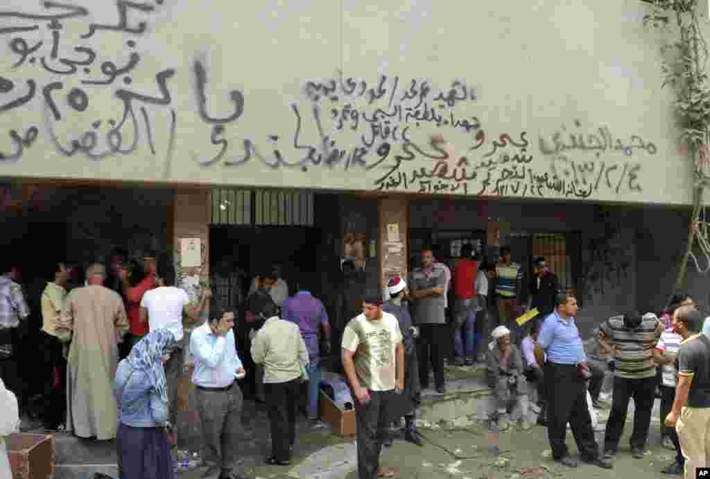 People gather at the Zenhoum morgue to identify loved ones and retrieve their bodies for burial following the deaths of hundreds of people in violence over the last week, in Cairo, August 19, 2013. 