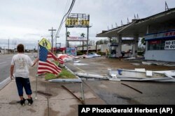 Dustin Amos walks near debris at a gas station on Thursday, Aug. 27, 2020, in Lake Charles, La., after Hurricane Laura moved through the state. (AP Photo/Gerald Herbert)