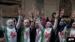 Những người biểu tình chống chế độ ở Syria mặc trang phục hình là cờ cách mạng Syria trong cuộc biểu tình ở Homs