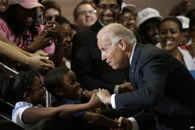 FILE - Vice President Joe Biden greets Lawrence Smith, 8, and Madison King, 9, both of Van Buren Township, Michigan, during a campaign stop at Renaissance High School in Detroit, Aug. 22, 2012.
