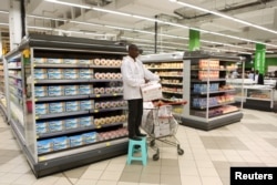 An employee works at the cheese section of Hyper Hayat supermarket at the newly expanded Cap Sud shopping mall in Abidjan, Ivory Coast, Sept. 14, 2015.