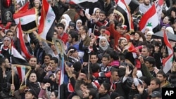 Syrians wave national flags as they rally in central Damascus in support of President Bashar al-Assad's, Nov. 16, 2011.
