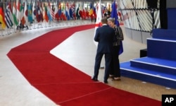 British Prime Minister Theresa May, right, speaks with European Council President Donald Tusk after a group photo at an EU-ASEM summit in Brussels, Oct. 19, 2018.