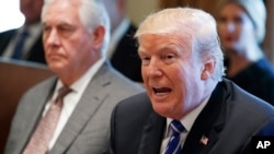 FILE - Secretary of State Rex Tillerson, left, listens as President Donald Trump speaks during a Cabinet meeting at the White House, Nov. 20, 2017, in Washington.