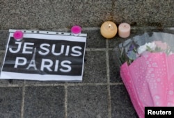 Candles, flowers and a leaflet with the slogan "I am Paris" are left in tribute to victims of Paris attacks in central Strasbourg, France, Nov. 14, 2015.