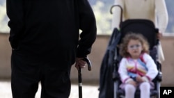 FILE - An elderly man (L) uses a cane to support his walk as he approches a child being pushed in a stroller, in Rome, Italy, April 27, 2007. Life expectancy worldwide rose by five years between 2000 and 2015, according to the World Health Organization.