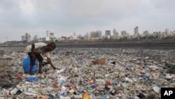 In this June 4, 2018, photo, a man collects plastic and other recyclable material from the shores of the Arabian Sea, littered with plastic bags and other garbage, in Mumbai, India. (AP Photo/Rafiq Maqbool, File)