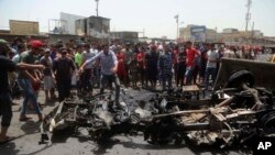 Civilians help a municipality bulldozer clean up while citizens inspect the scene after a car bomb explosion at a crowded outdoor market in the Iraqi capital's eastern district of Sadr City, Iraq, Wednesday, May 11, 2016.