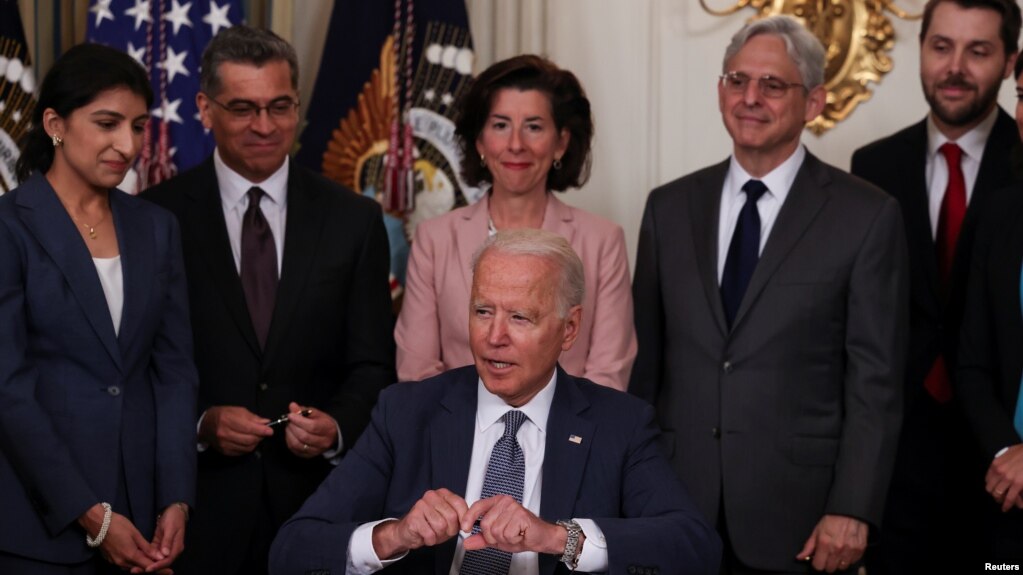 拜登总统在内阁成员簇拥下在白宫国宴厅签署推动美国经济竞争的行政命令。(2021年7月9日)(photo:VOA)
