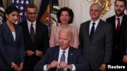 拜登總統在內閣成員簇擁下在白宮國宴廳簽署推動美國經濟競爭的行政命令。(2021年7月9日)