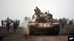 Turkish army tanks enter Afrin, an enclave in northern Syria controlled by U.S.-allied Kurdish fighters, in Hassa, Hatay, Turkey, Jan. 22, 2018. 