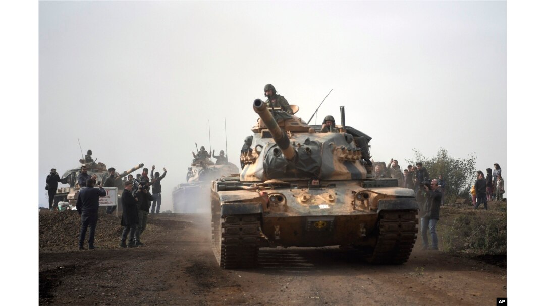 FILE - Turkish army tanks enter Afrin, an enclave in northern Syria controlled by U.S.-allied Kurdish fighters, in Hassa, Hatay, Turkey, Jan. 22, 2018.