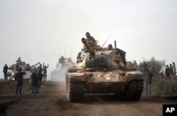 Turkish army tanks enter Afrin, an enclave in northern Syria controlled by U.S.-allied Kurdish fighters, in Hassa, Hatay, Turkey, Jan. 22, 2018.