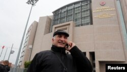 Ali Riza Tolu, father of imprisoned German journalist Mesale Tolu, talks with his mobile phone in front of the Justice Palace, the Caglayan courthouse, in Istanbul, Turkey, Dec. 18, 2017. 